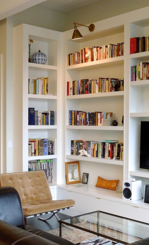 Built-in Bookshelf: White Corner Shelving with Tufted Chair
