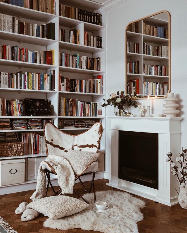 Butterfly Chair: Hygge Style with Cowhide Print & Floor-to-Ceiling Shelves.