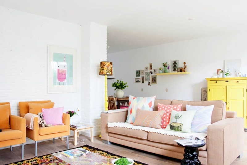 Cheerful Living Room with White Brick Walls and Orange Accent Chairs