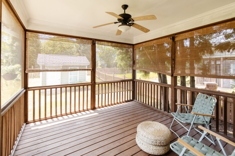 Coastal Porch with Bamboo Blinds, Stacked Woven Poufs & Folding Chairs.