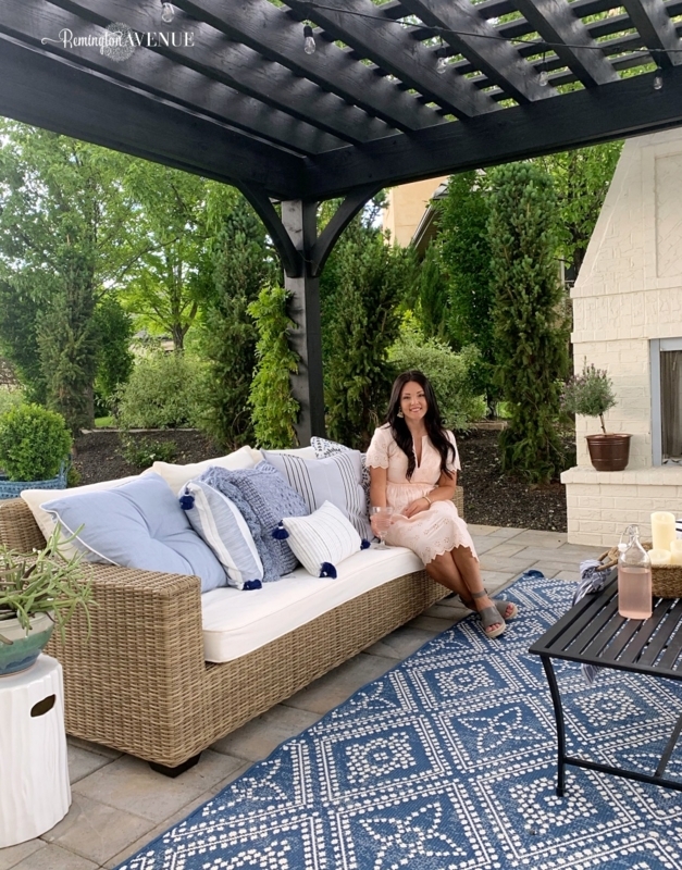 Coastal Wicker Outdoor Sofa and Blue Rug under Black Pergola Structure
