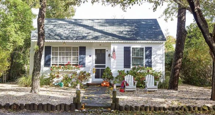 Cozy Autumn Cottage Exterior with White Adirondack Chairs