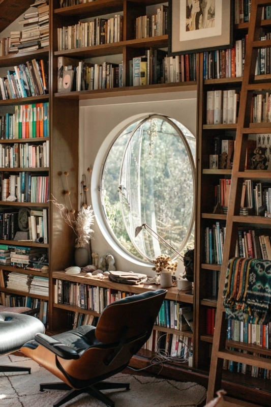 Cozy Reading Nook Library with Large Circular Window and Bentwood Chair