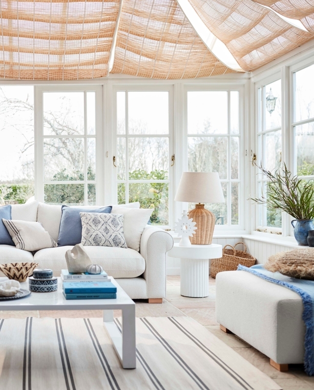 Cream Rolled Arm Sofa in Coastal Sunroom with Woven Ceiling Shades