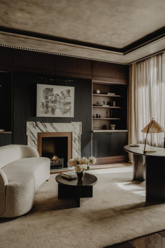 Dark Paneled Wall Living Room: Curved Boucle Sofa & Marble Fireplace