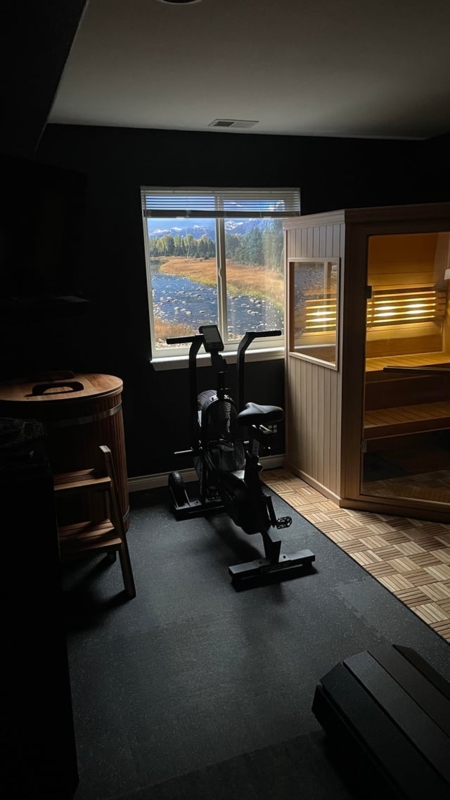Dark Wellness Room With Sauna, Wooden Tub, And Scenic Window Backdrop