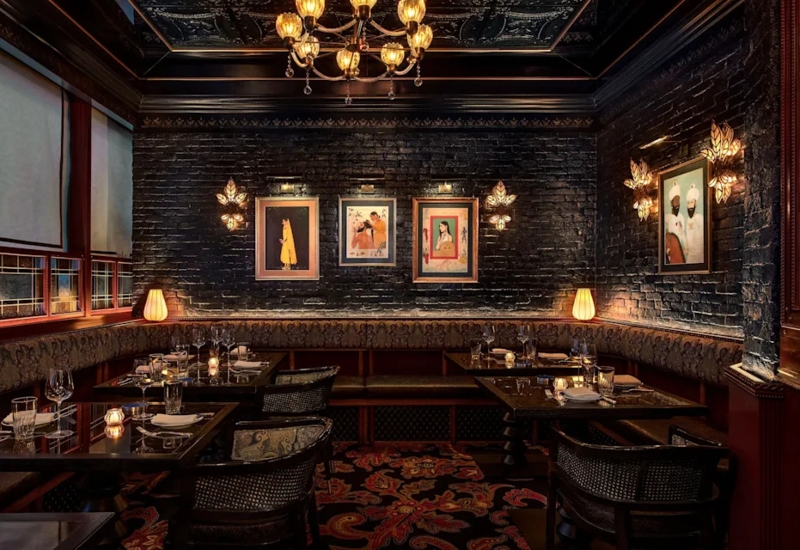 Dining Room: Black Brick Walls, Gold Leaf Sconces, Ornate Floral Rug