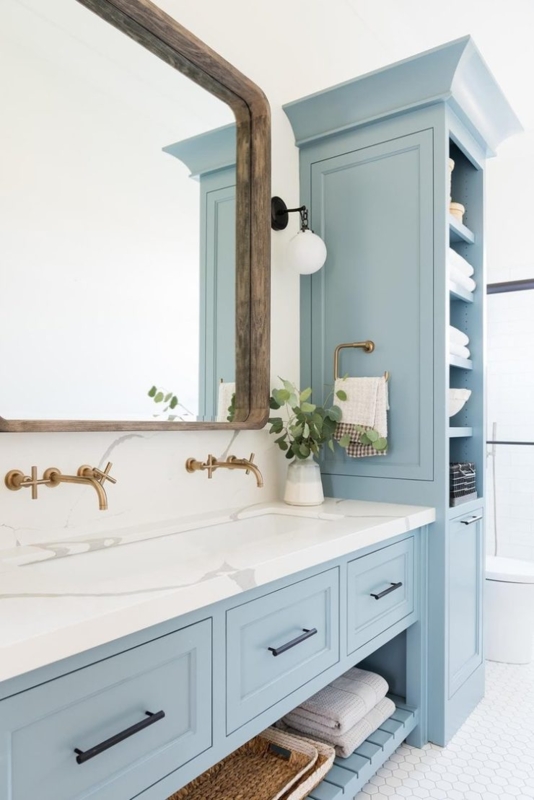 Dusty Blue Vanity with Wall Mounted Brass Faucets and Built-in Storage
