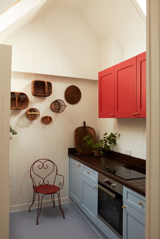 Eclectic Galley Kitchen: Color Blocked Cabinets and Woven Wall Decor