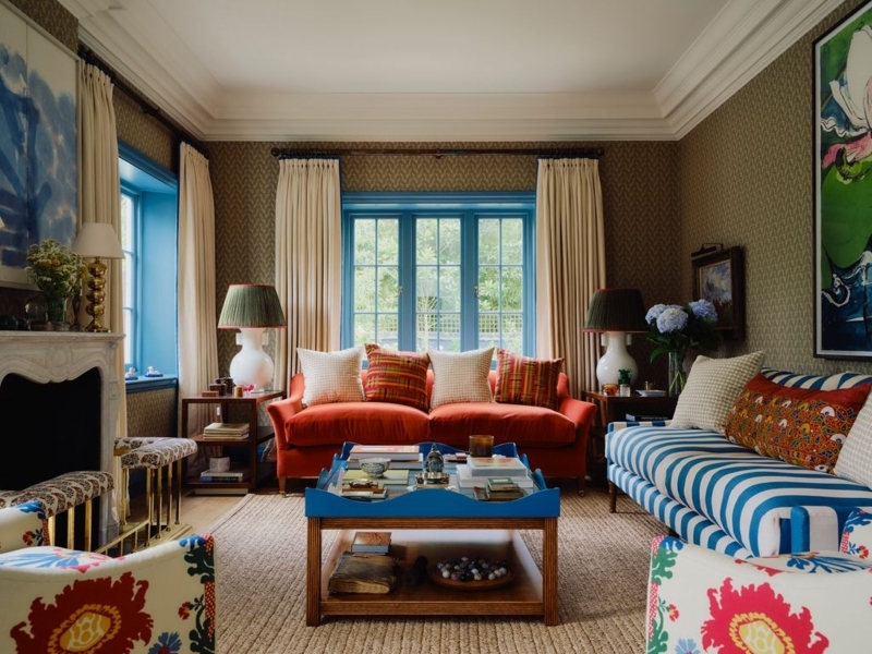 Eclectic Living Room Palette: Blue Window Trim & Mixed Bold Patterns.