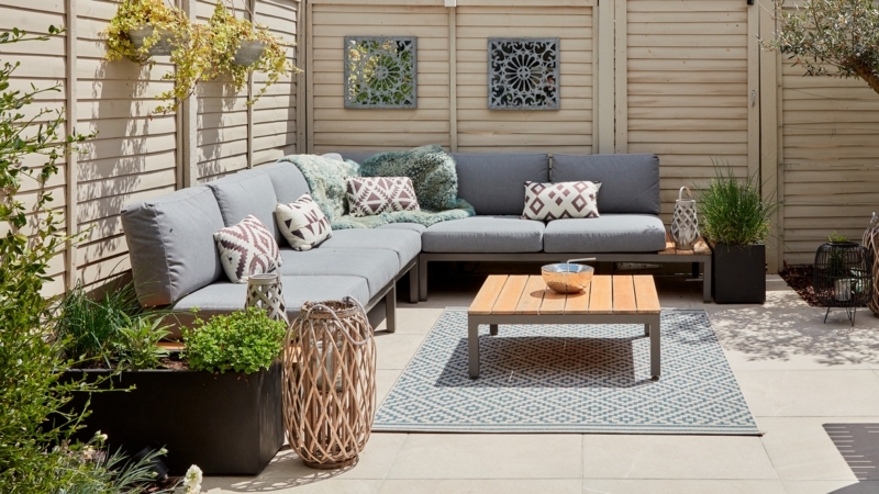 Enclosed Patio Garden with Outdoor Sectional and Geometric Area Rug