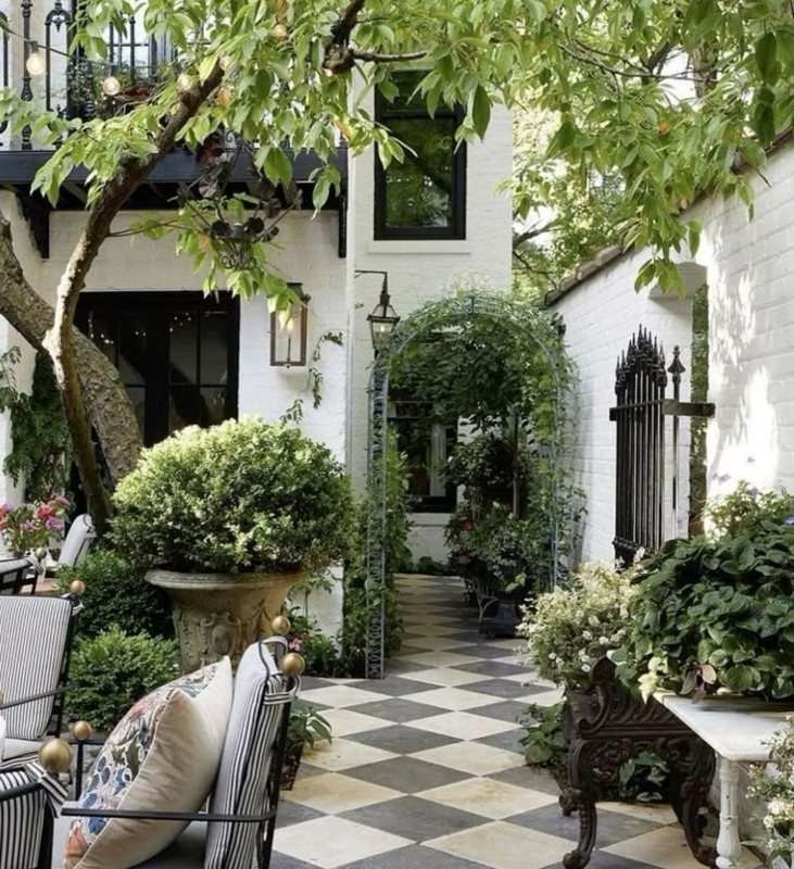 European Courtyard Garden with Checkerboard Floor and Arched Trellis