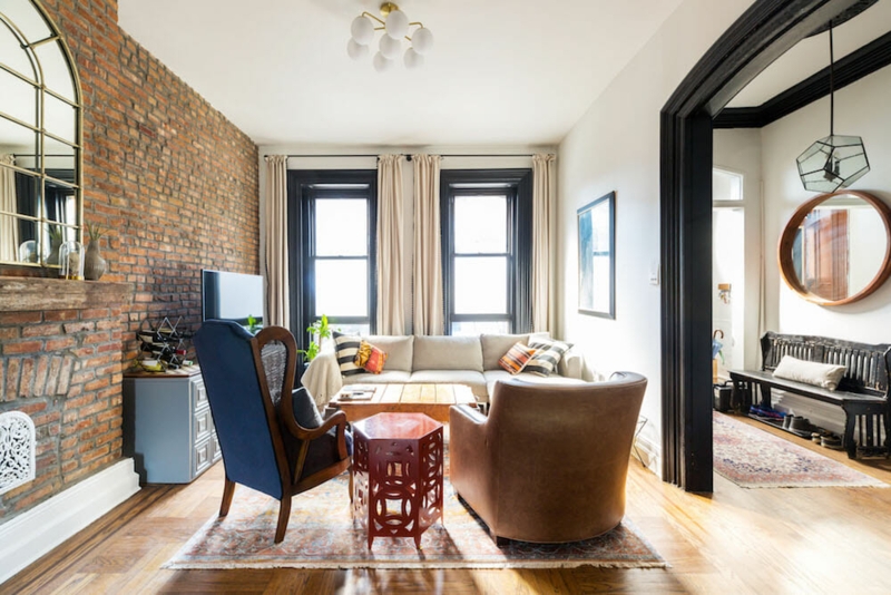 Exposed Brick Wall Living Room with Black Arched Doorway Transition