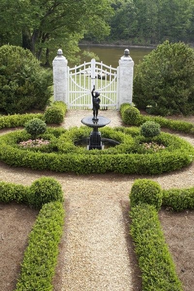 Formal European Garden featuring Symmetrical Hedges and White Gate