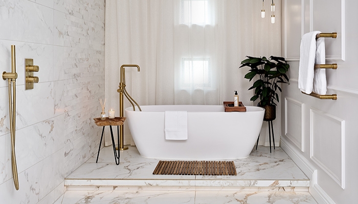 Freestanding Bathtub with Brass Fixtures and Marble Tile Surround