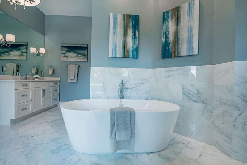 Freestanding Bathtub with Marble Wainscoting and Vertical Wall Art