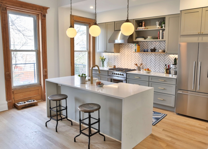 Grey Cabinets with White Waterfall Island and Ornate Window Trim