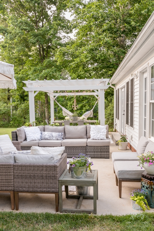Grey Woven Patio Sectional under White Pergola with Hammock