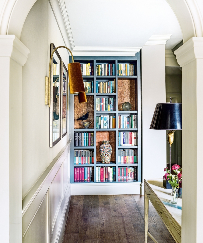 Hallway Library with Arched Architectural Framing and Blue Shelving