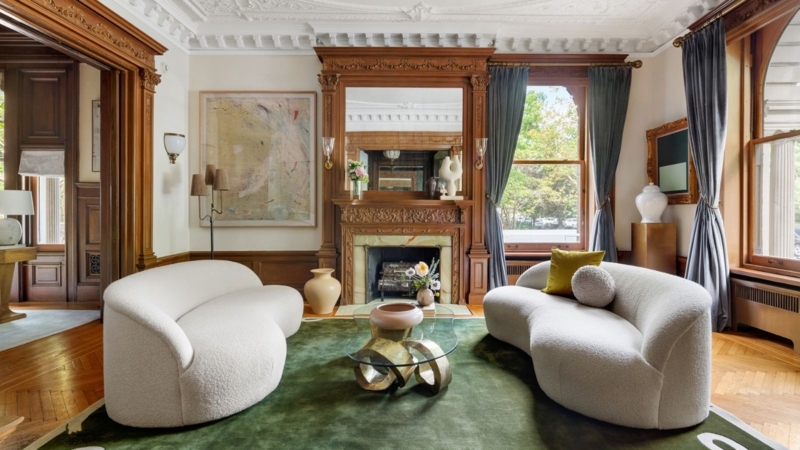 Historic Interior with Kidney Shaped Sofas & Ornate Wood Mantel