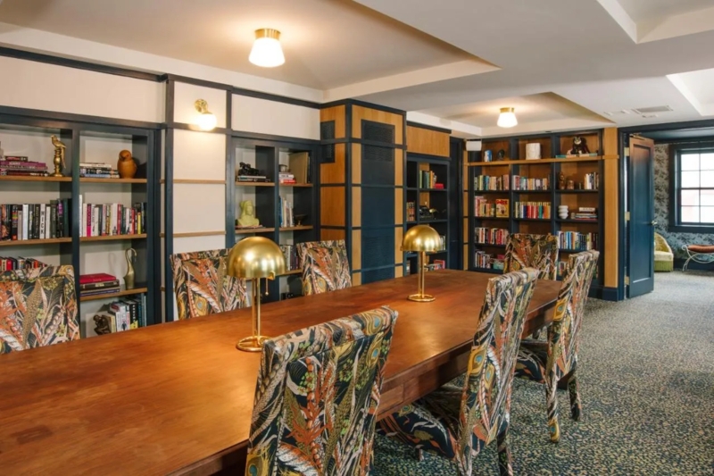 Home Library with Navy Built-in Bookcases and Botanical Chairs
