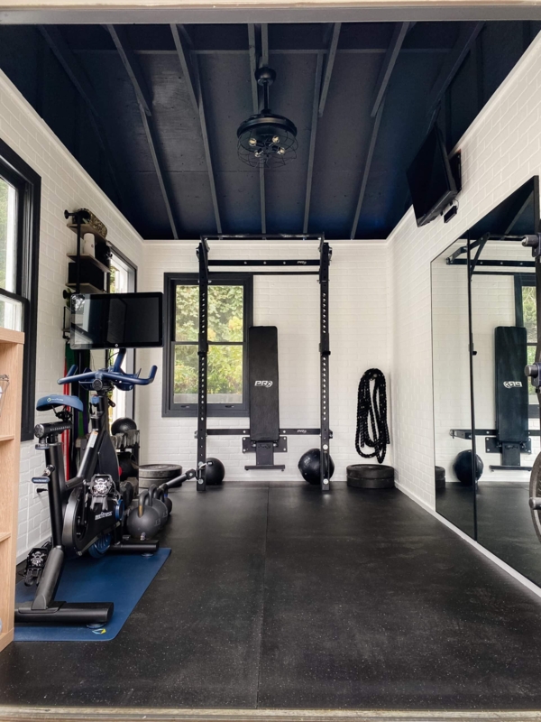 Industrial Garage Gym With Black Exposed Ceiling And Brick Walls