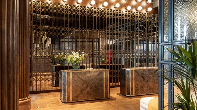 Industrial Luxury Lobby: Brass Folding Screens, Fluted Wood Columns