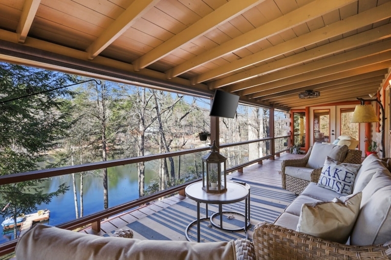 Lakeside Porch Seating Area with Wicker Furniture and Exposed Rafters