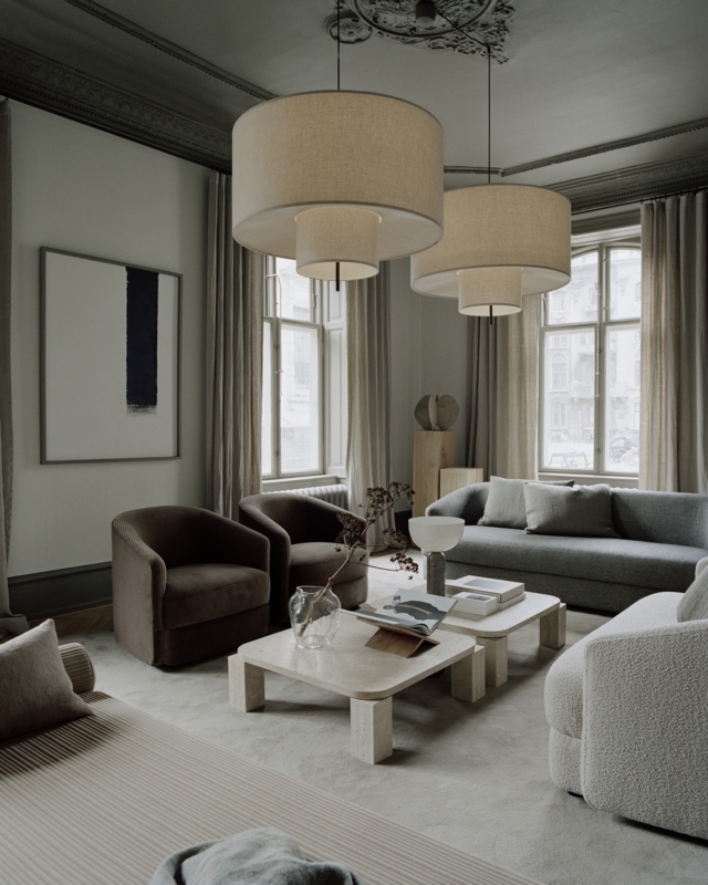 Living Room Tonal Layering with Tiered Pendants and Stone Tables