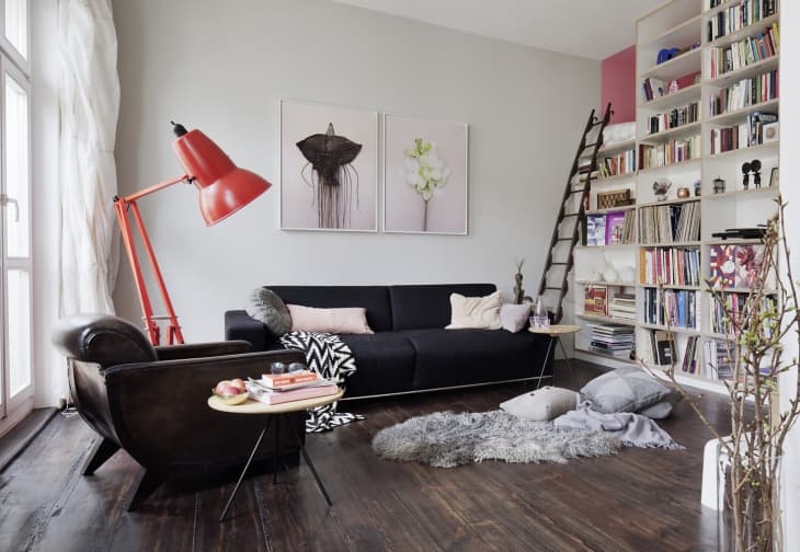 Living Room with Oversized Red Floor Lamp and Floor to Ceiling Library