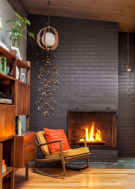 Mid-Century Modern Rocking Chair: Yellow Upholstery & Dark Brick Fireplace.