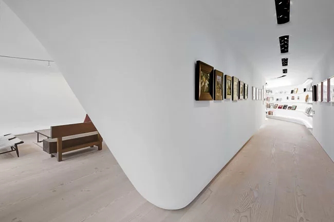 Minimalist Gallery Loft: Sculptural Curved Wall & Light Wood Flooring