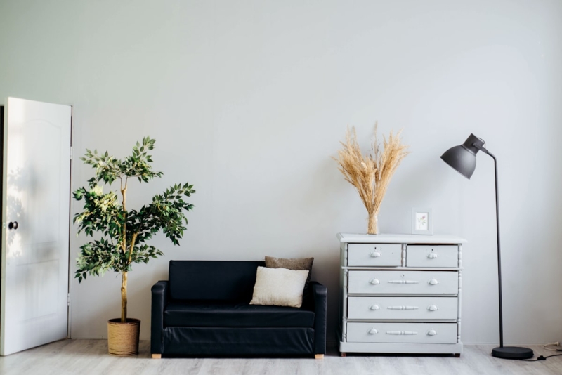 Minimalist Living Room Corner with High-Contrast Black Loveseat & Lamp