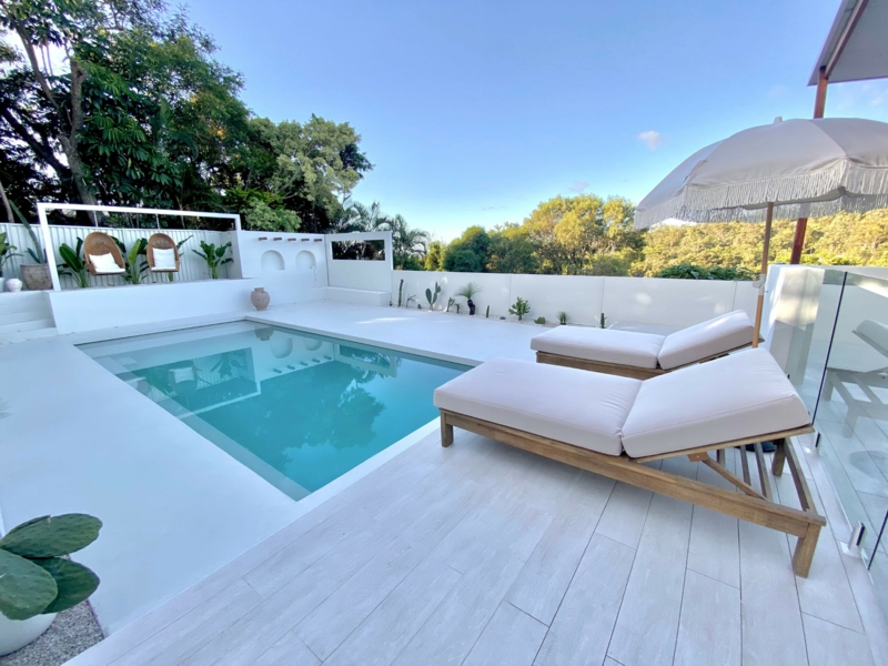 Minimalist Mediterranean Pool with Fringe Umbrella and White Masonry
