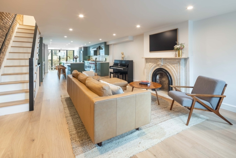 Modern Brownstone Living Room Layout with Ornate Fireplace Mantel