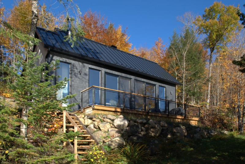 Modern Cabin Exterior with Black Metal Roof and Stone Retaining Wall