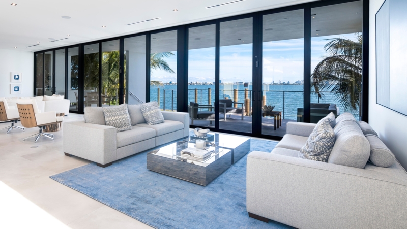 Modern Coastal Living Room with Mirrored Coffee Table and Glass Walls