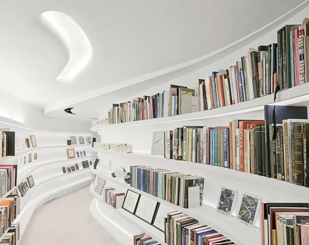 Modern Hallway Library with Curved Built-In Shelving & Boomerang Light