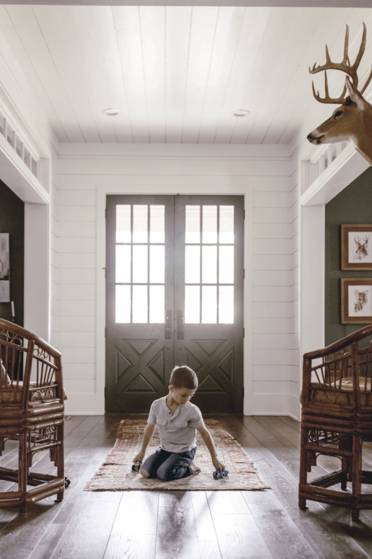 Modern Heritage Entryway Featuring Dark Charcoal Doors & Rattan Chairs