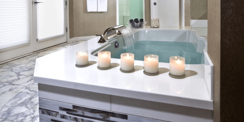 Modern Luxury Bathtub with Waterfall Faucet & Serene Candle Arrangement