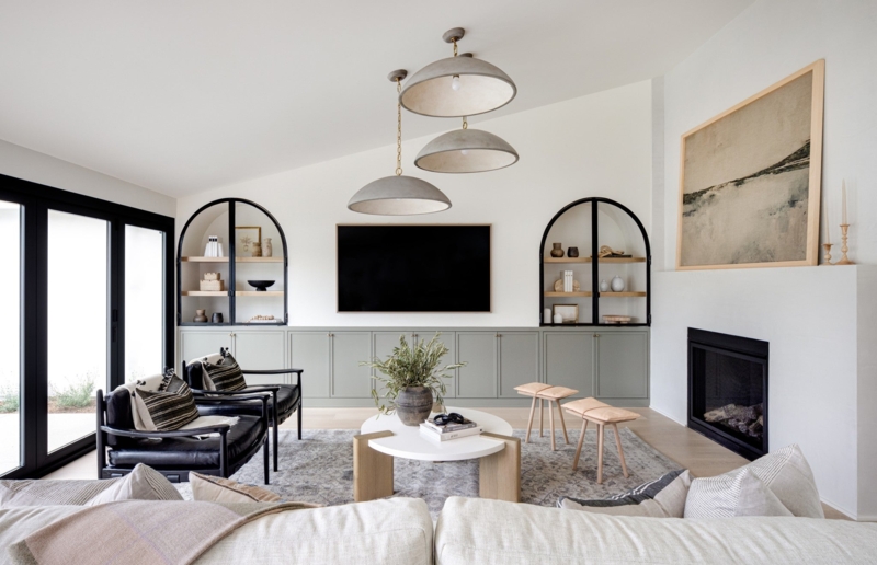 Modern Organic Living Room: Sage Green Cabinetry & Arched Black Frames.