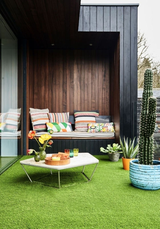 Modern Outdoor Seating Nook: Dark Wood Cladding & Artificial Turf