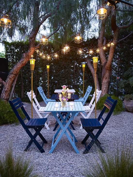 Multi Colored Seating Dining Set on Gravel Patio with String Lights