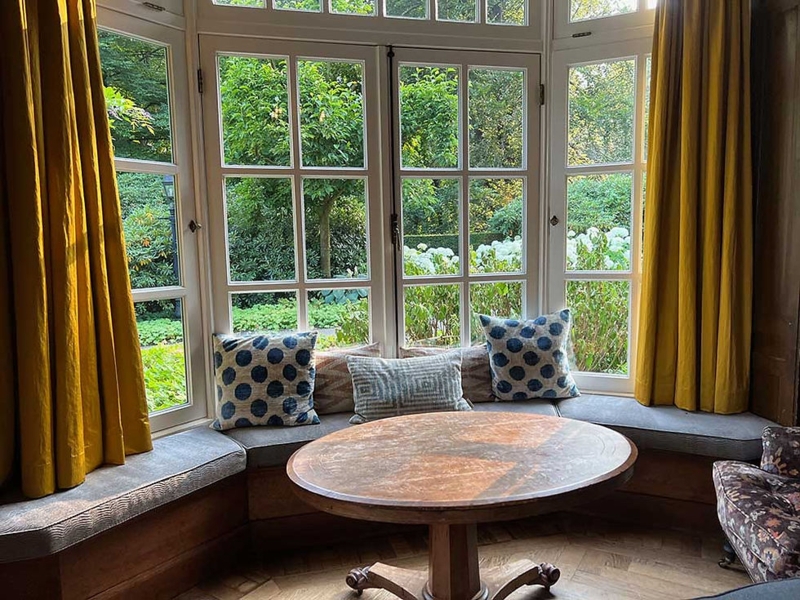 Mustard Yellow Curtains Window Seat Nook with Round Pedestal Table.
