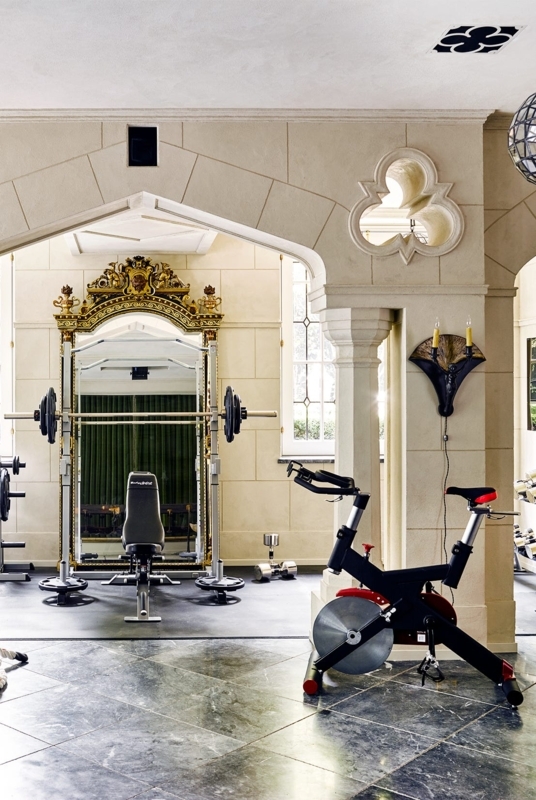 Neoclassical Home Gym With Stone Cladded Arches And Ornate Mirror