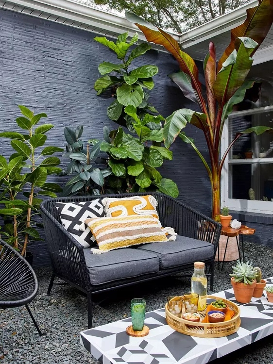 Outdoor Loveseat Black Woven Rope Dark Brick Backdrop Tropical Patio