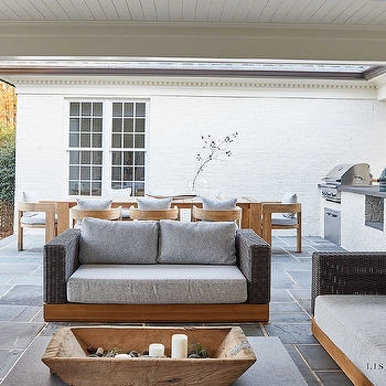 Outdoor Sofa with Wood Base against White Brick Backdrop