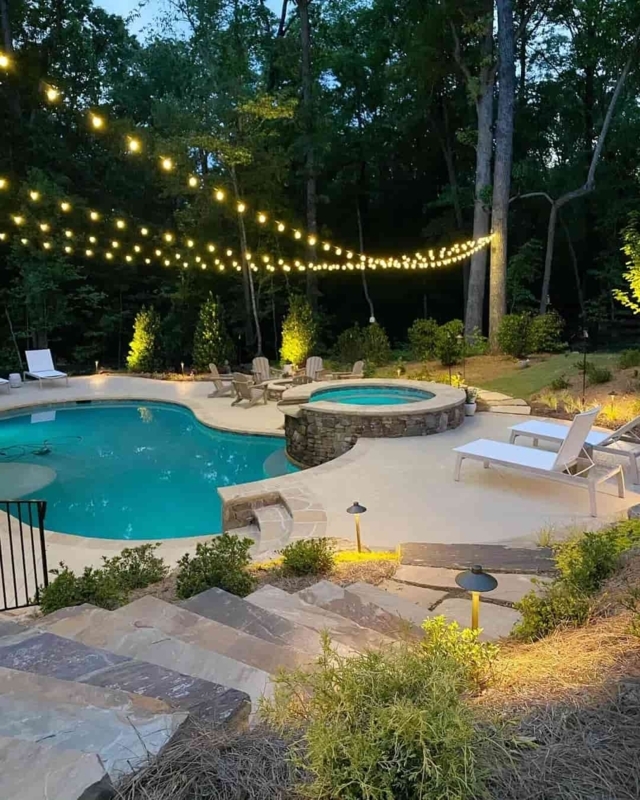 Pool Area with Stone Clad Spa, String Lights, and Resort Style Decor