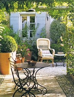 Provencal Patio with Mixed Seating under Lush Overhead Vine Canopy
