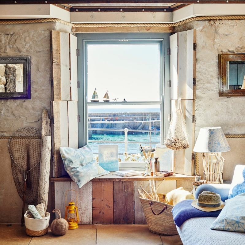Rustic Coastal Window Nook with Stone Walls and Built-In Seating